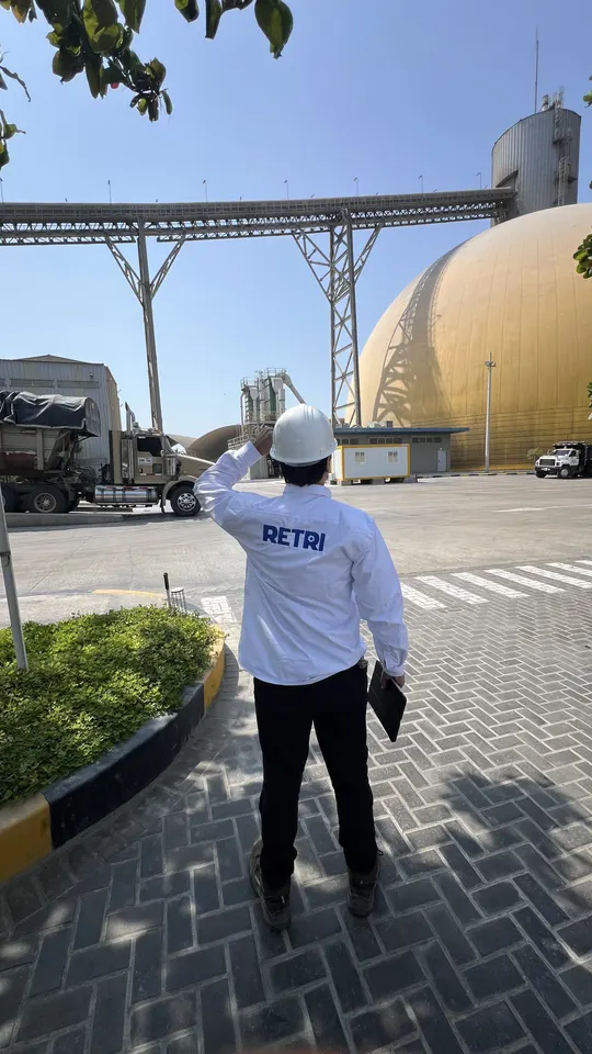 Supervisor de Retri con casco en la planta de cemento de Ultracem, frente al domo de almacenamiento